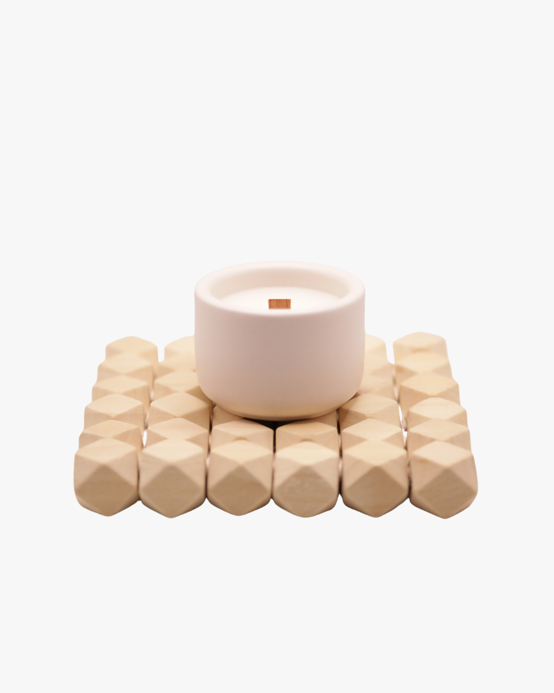 Mini bougie parfumée Nicaise « Moment Si Doux » en pot blanc avec mèche en bois, posée sur un support en bois, sur fond blanc.