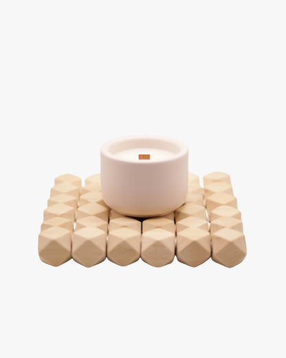 Mini bougie parfumée Nicaise « Moment Si Doux » en pot blanc avec mèche en bois, posée sur un support en bois, sur fond blanc.