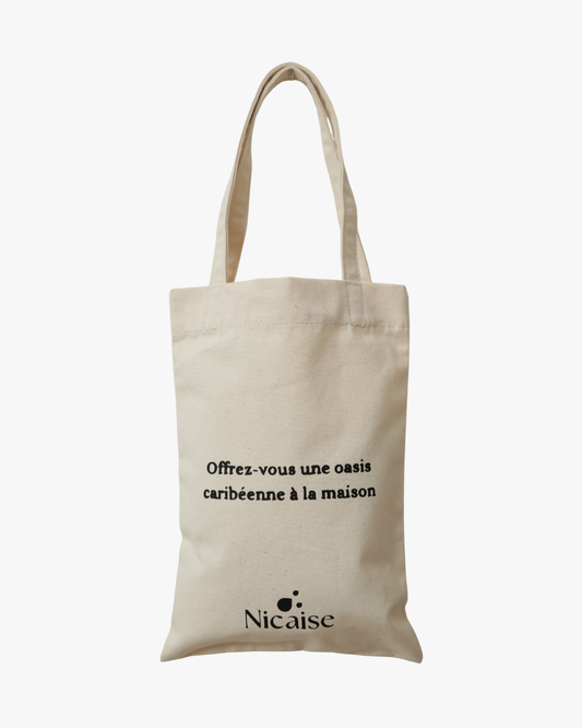 Mini tote bag Nicaise en toile beige avec slogan « Offrez-vous une oasis caribéenne à la maison », sur fond blanc.